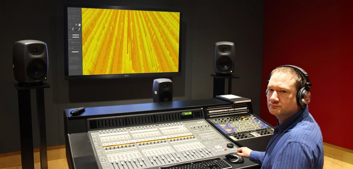Dr. Bill Evans seated in front of a mixing console with the native Belexes Virtual Audio Workstation interface in front of him.