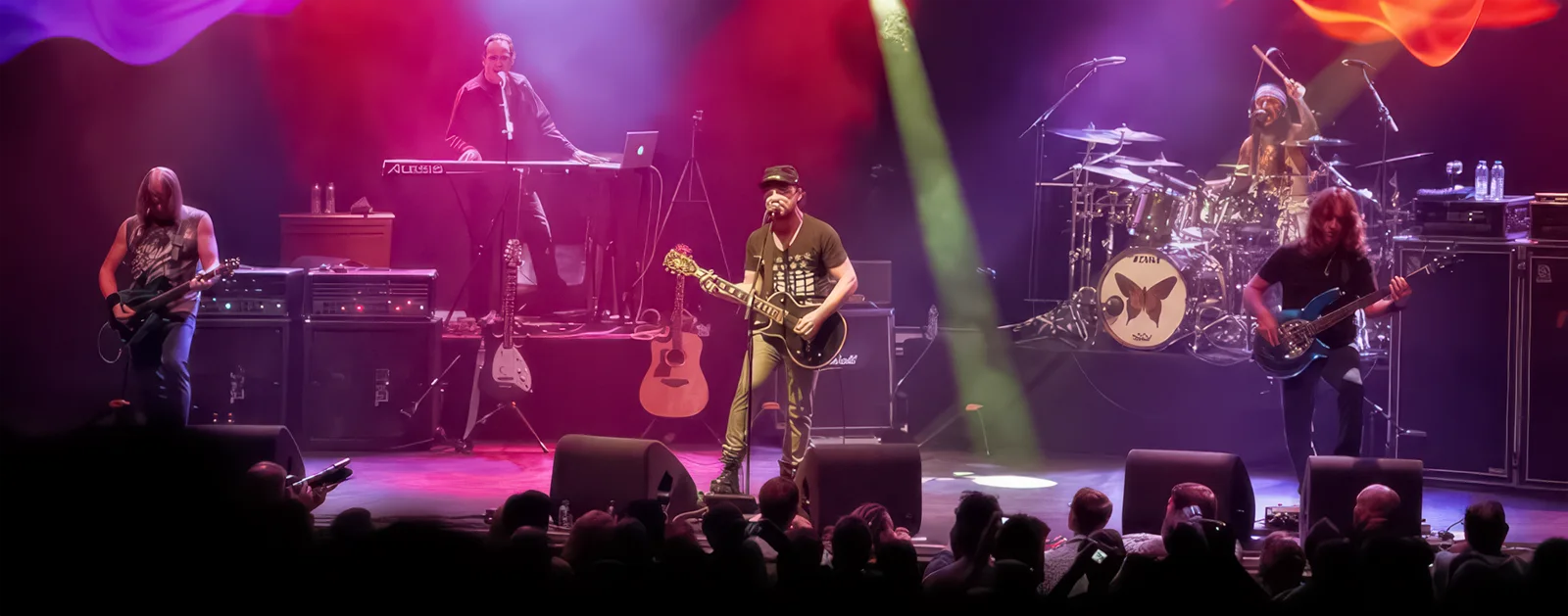 A close-up of the group Flying Colors performing on a colourfully-lit stage.